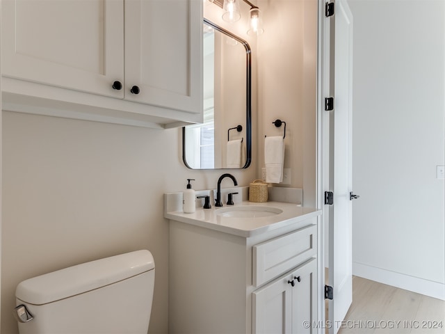 bathroom with vanity, wood-type flooring, and toilet