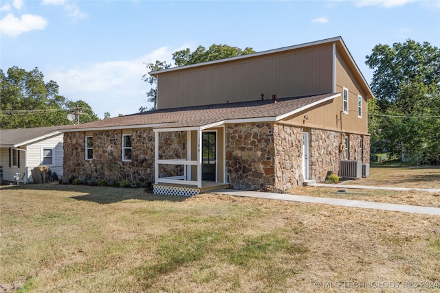 back of property featuring a lawn and cooling unit