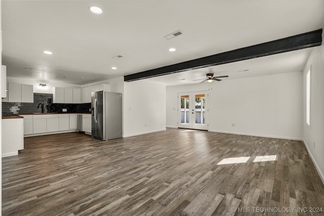 unfurnished living room with ceiling fan, french doors, beamed ceiling, and hardwood / wood-style flooring