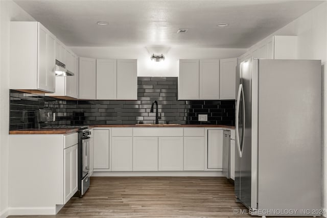 kitchen with white cabinets, appliances with stainless steel finishes, light hardwood / wood-style flooring, and sink