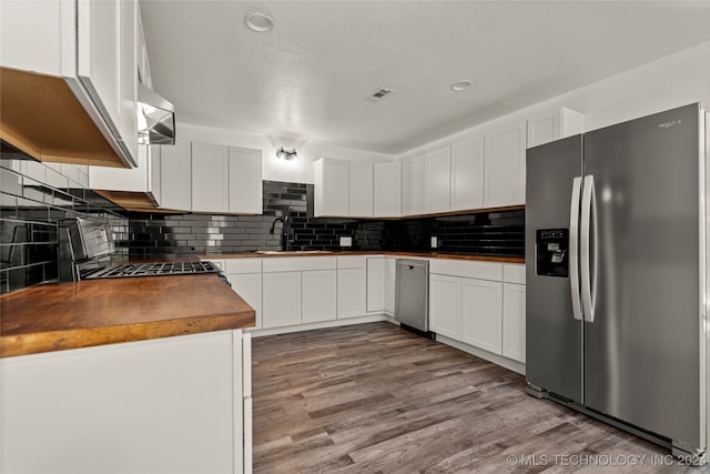 kitchen featuring stainless steel appliances, butcher block countertops, white cabinetry, and light hardwood / wood-style floors