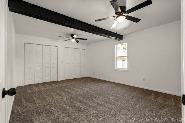 unfurnished bedroom featuring carpet, ceiling fan, and beam ceiling