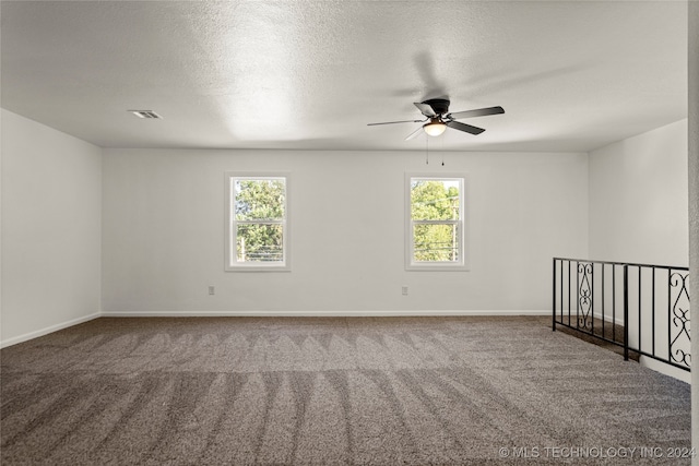 carpeted spare room featuring ceiling fan and a textured ceiling