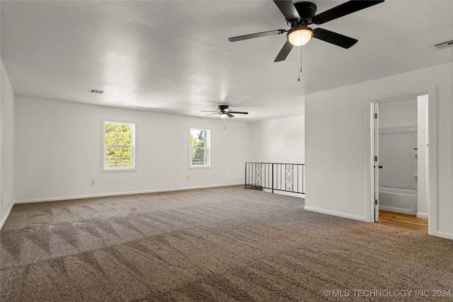 empty room with ceiling fan, carpet floors, and a textured ceiling