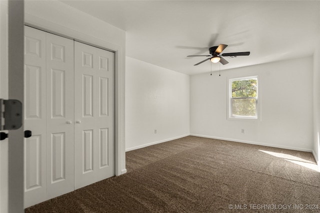 interior space featuring dark colored carpet and ceiling fan