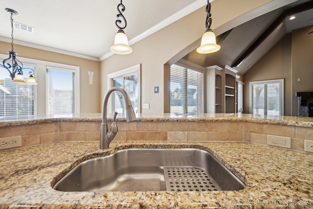 kitchen featuring a notable chandelier, crown molding, sink, and a wealth of natural light