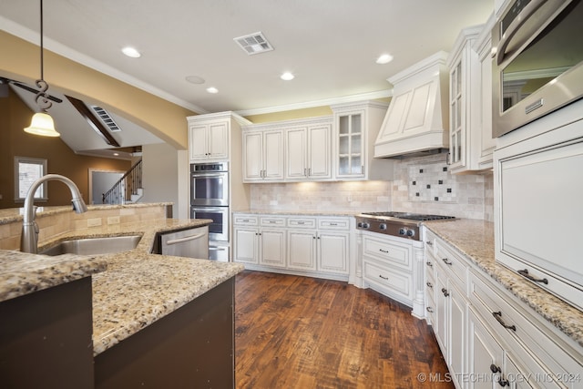 kitchen featuring dark hardwood / wood-style floors, sink, hanging light fixtures, custom exhaust hood, and appliances with stainless steel finishes