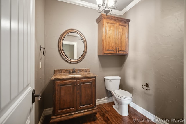 bathroom featuring vanity, wood-type flooring, ornamental molding, toilet, and a chandelier