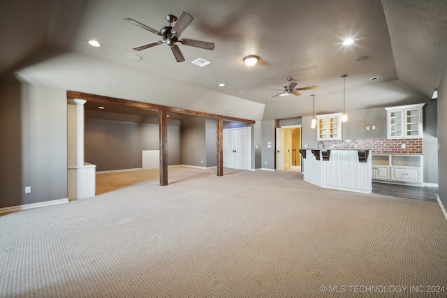 unfurnished living room featuring light carpet, ceiling fan, and ornate columns