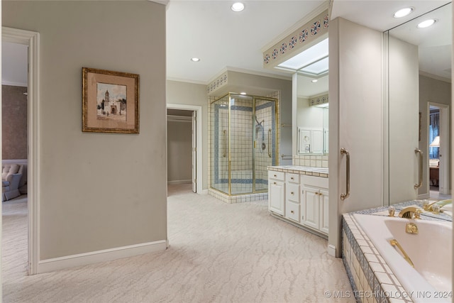 bathroom with a skylight, vanity, plus walk in shower, and ornamental molding