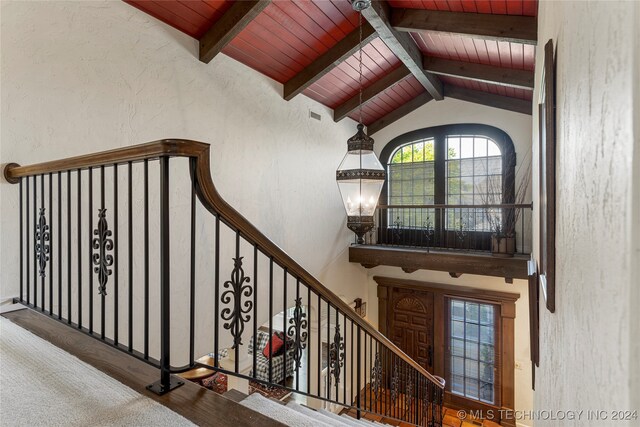 stairway with lofted ceiling with beams, wood ceiling, a chandelier, and wood-type flooring