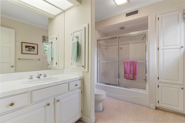 full bathroom featuring ornamental molding, vanity, toilet, and bath / shower combo with glass door