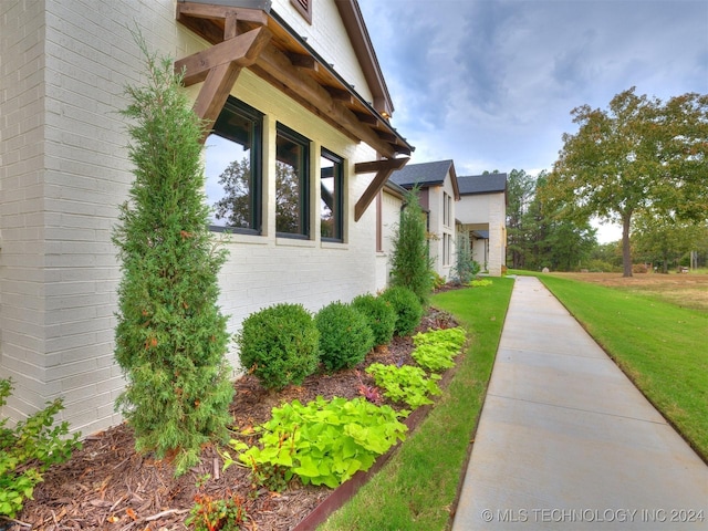 view of side of home with a yard