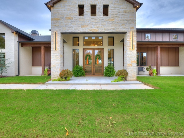 entrance to property with a lawn and french doors