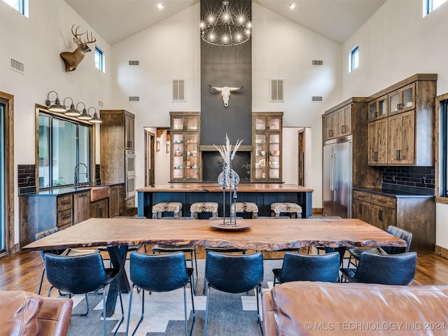 kitchen with decorative backsplash, dark wood-type flooring, stainless steel appliances, and a high ceiling