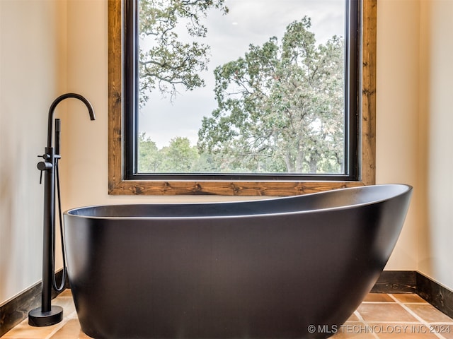 bathroom featuring tile patterned floors and a bath