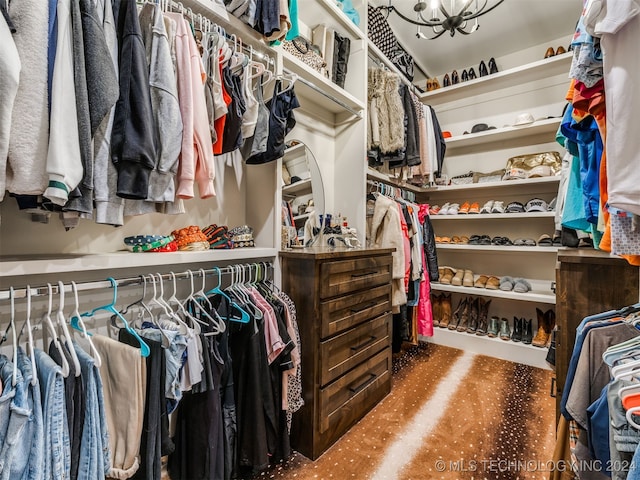 walk in closet featuring a notable chandelier