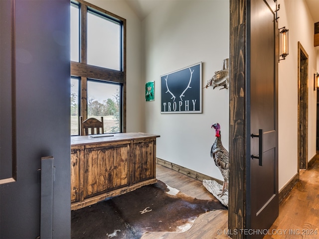 foyer entrance with hardwood / wood-style floors and vaulted ceiling