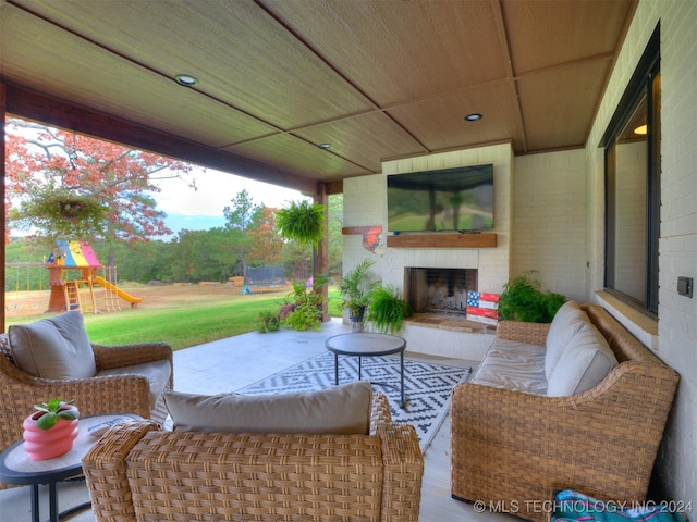 view of patio / terrace with a large fireplace, a playground, and a trampoline