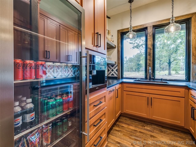 kitchen featuring decorative light fixtures, sink, and dark wood-type flooring