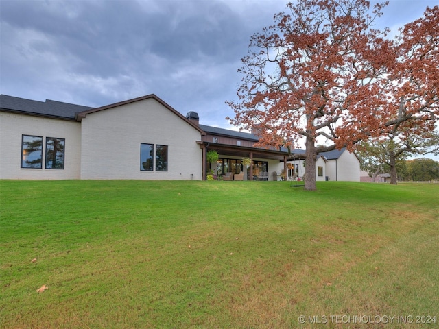 rear view of house featuring a lawn