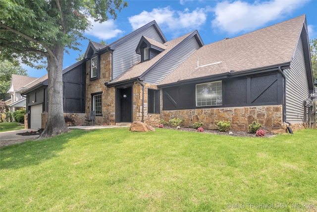 view of property with a garage and a front lawn