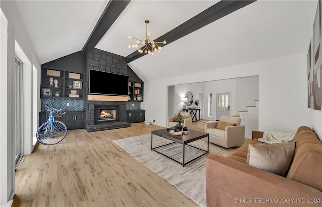 living room featuring lofted ceiling with beams, light hardwood / wood-style flooring, an inviting chandelier, and a stone fireplace