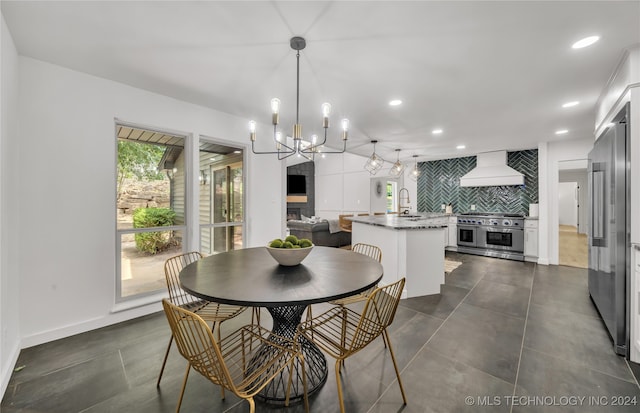 dining room featuring sink and a notable chandelier