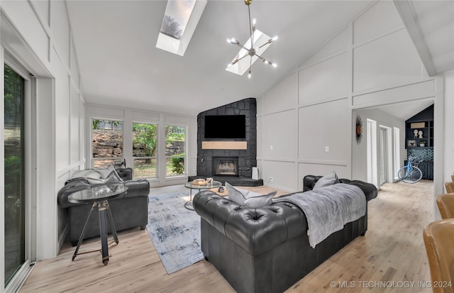 living room featuring light hardwood / wood-style floors, a fireplace, a skylight, and high vaulted ceiling