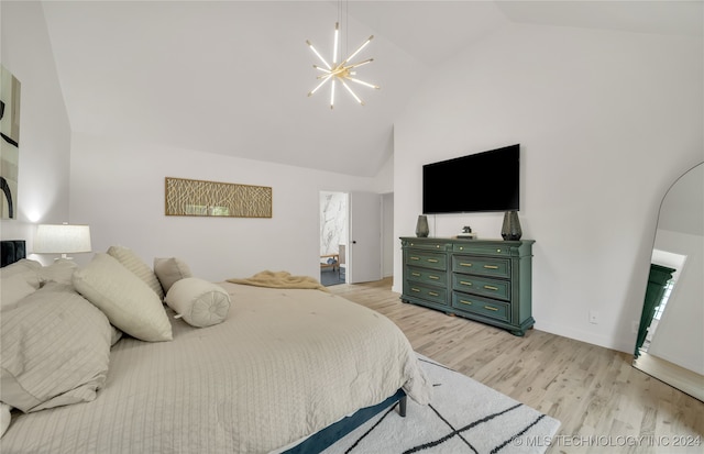 bedroom with an inviting chandelier, light hardwood / wood-style flooring, and high vaulted ceiling