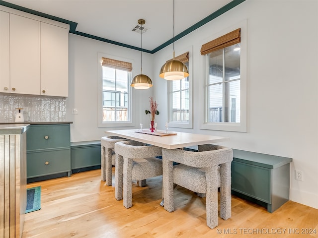 dining area featuring ornamental molding and light hardwood / wood-style floors