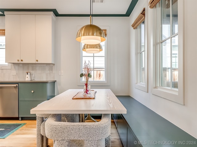 dining space with light hardwood / wood-style flooring and crown molding