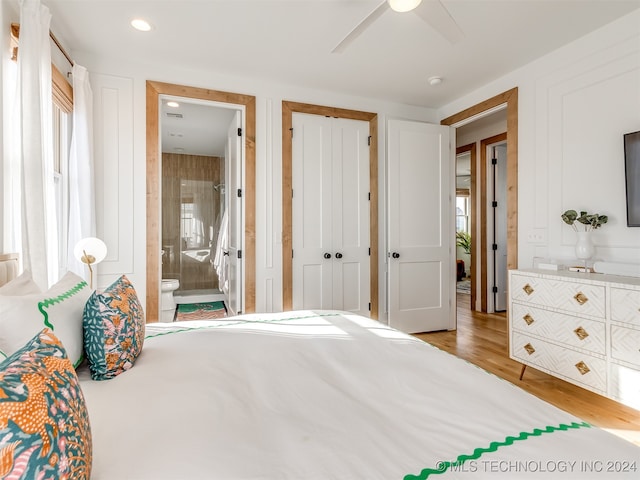 bedroom with ceiling fan, light wood-type flooring, and ensuite bath