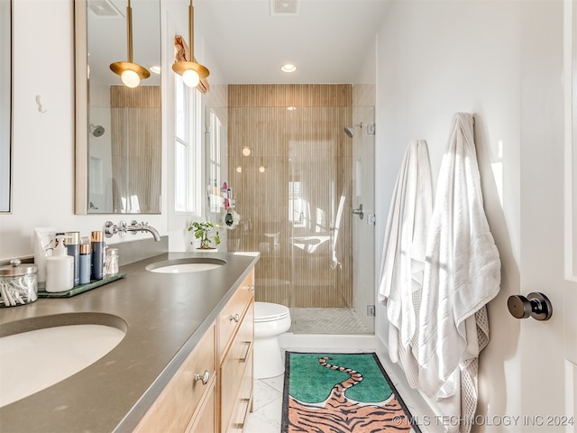 bathroom with vanity, toilet, tile patterned floors, and a shower with door