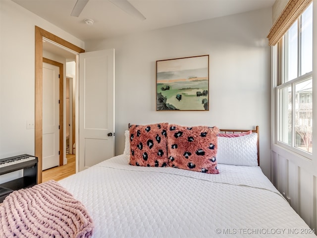 bedroom featuring ceiling fan, light wood-type flooring, and multiple windows