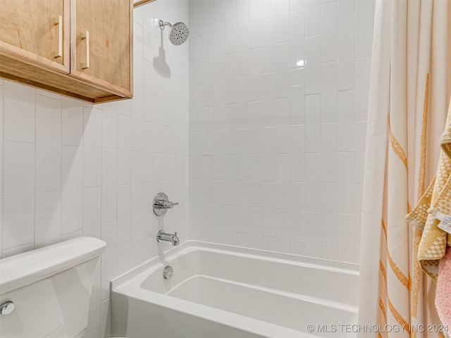 bathroom featuring shower / tub combo with curtain and toilet