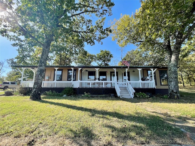 ranch-style home featuring covered porch and a front lawn