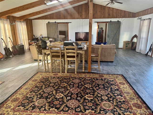 dining room with ceiling fan, a barn door, and lofted ceiling with beams