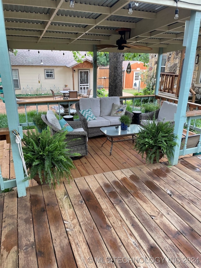 wooden deck featuring an outdoor hangout area, ceiling fan, and a shed