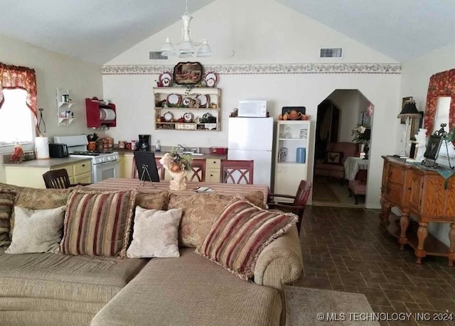 living room with a notable chandelier, vaulted ceiling, and sink