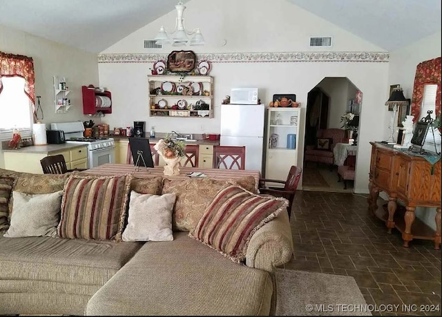 living room with lofted ceiling, an inviting chandelier, and sink