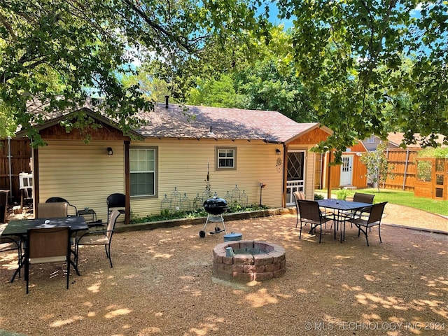 back of property featuring a fire pit and a patio