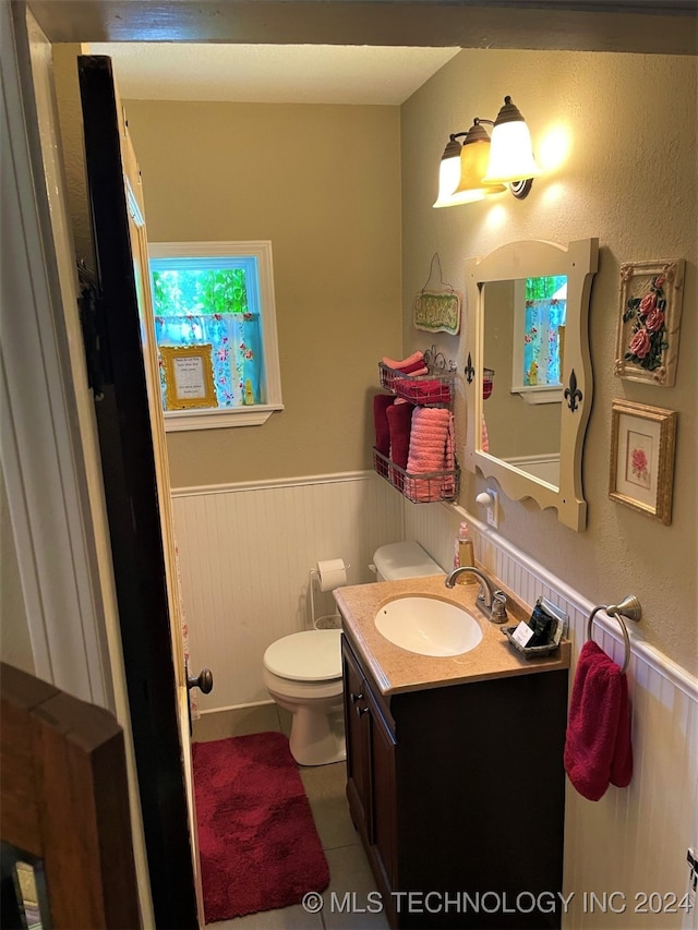 bathroom featuring tile patterned flooring, vanity, and toilet