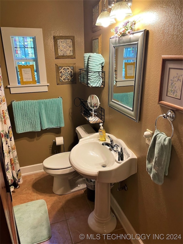 bathroom with toilet and tile patterned floors