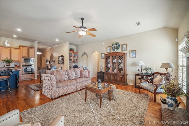 living room with ceiling fan, lofted ceiling, and dark hardwood / wood-style flooring