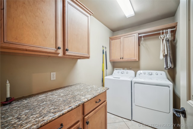 clothes washing area featuring cabinets, independent washer and dryer, and light tile patterned flooring