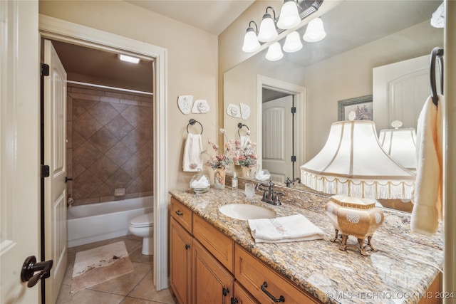 full bathroom with tile patterned floors, tiled shower / bath, vanity, and toilet