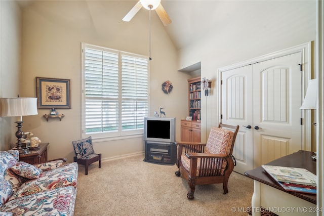 living area featuring light carpet, vaulted ceiling, and ceiling fan