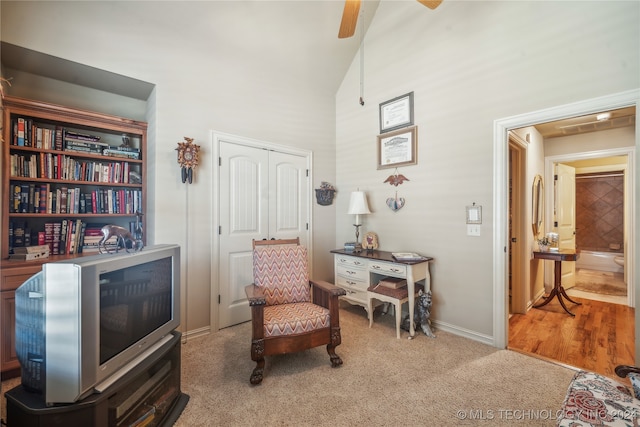 living area with ceiling fan, lofted ceiling, and hardwood / wood-style floors