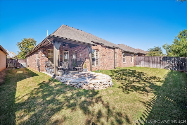 back of house with a lawn and a patio area